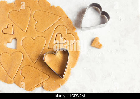 Faire des cookies en forme de cœur de gingembre pâte crue - des biscuits de fête pâtisserie pour la Saint-Valentin Banque D'Images