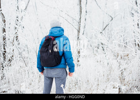 Jeune homme tout seul dans l'hiver la forêt enneigée Banque D'Images