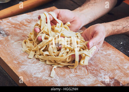 Les mains des hommes de prendre des pâtes Banque D'Images