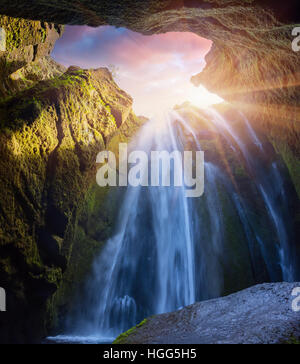 Vue de dessous de belle cascade - Seljalandfoss. Lever du soleil d'été coloré dans le canyon en Islande, région sud, l'Europe. Banque D'Images