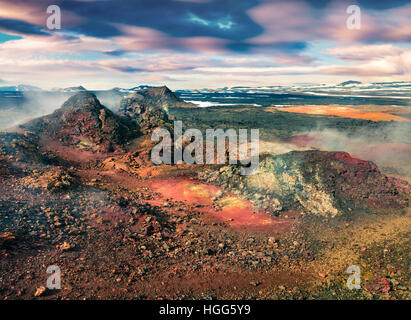 Champs d'eaux chaudes dans le volcan Krafla. Avec le coucher du soleil exotique de couleur au sol de lave dans la vallée géothermique Leirhnjukur. Banque D'Images