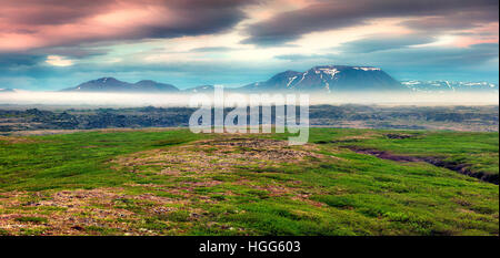 Paysage islandais typique avec des montagnes à l'horizon brumeux. Lever du soleil d'été colorés près du lac Myvatn situé à, l'Islande, l'Europe. Style artistique Banque D'Images
