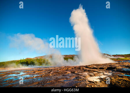 Éruption du Grand Geyser se trouve dans la vallée de Haukadalur sur les pentes du Laugarfjall hill. Tôt le matin dans le sud-ouest de l'Islande. Banque D'Images