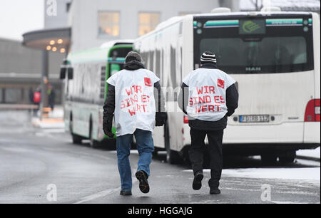 Fulda, Allemagne. Jan 9, 2017. Deux chauffeurs de bus en grève avec vestes lire 'Nous sommes en valeur elle à pied passé des autobus scolaires de la gare d'autobus de l'RhoenEnergie à Fulda, Allemagne, le 9 janvier 2017. Le syndicat Verdi a appelé à une grève illimitée, large de conducteurs de bus en Hesse. Verdi est en train de négocier une nouvelle convention collective accord salarial avec l'état de Hesse association entreprises Omnibus. Photo : Arne Dedert/dpa/Alamy Live News Banque D'Images