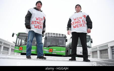 Fulda, Allemagne. Jan 9, 2017. Deux chauffeurs de bus en grève avec vestes lire 'Nous sommes en valeur elle' devant des autobus scolaires de la gare d'autobus de l'RhoenEnergie à Fulda, Allemagne, le 9 janvier 2017. Le syndicat Verdi a appelé à une grève illimitée, large de conducteurs de bus en Hesse. Verdi est en train de négocier une nouvelle convention collective accord salarial avec l'état de Hesse association entreprises Omnibus. Photo : Arne Dedert/dpa/Alamy Live News Banque D'Images