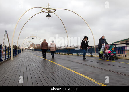 Jetée de Southport, Merseyside, Royaume-Uni. 9 janvier, 2017. Météo britannique. Les marcheurs courageux de fortes averses et des vents soufflant à la promenade de la vieille structure victorienne. Les prévisions de vent pour revenir vers le nord-ouest plus tard, avec éclaircies et averses hivernales susceptibles. Les piliers sont un symbole unique du bord de l'Angleterre victorienne et passées et présentes sont architecture balnéaire à son meilleur. © MediaWorldImages/Alamy Live News Banque D'Images