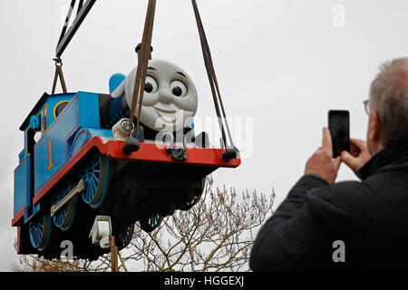 Eastbourne, Royaume-Uni. 9 janvier, 2017. Un spectateur utilise son téléphone pour capturer Thomas le réservoir du moteur alors qu'il est soulevé dans les airs par une grue pour son dernier voyage familial au zoo, parc Drusillas, Alfriston près de Eastbourne, East Sussex, UK, lundi 9 janvier 2017. Comme London Underground Tube les trains sont arrêtés par les grèves, le moteur 3,5 tonne Thomas a été levée par les rails de grue, de même que les voitures à voyageurs, Annie et Clarabel et marque la fin de la ligne pour Thomas après dix ans à Drusillas. Credit : Luke MacGregor/Alamy Live News Banque D'Images