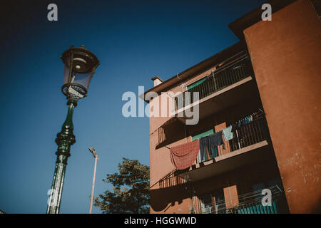 La maison rouge avec balcon et , étendus dehors et une lampe de rue à Venise, Italie. Banque D'Images