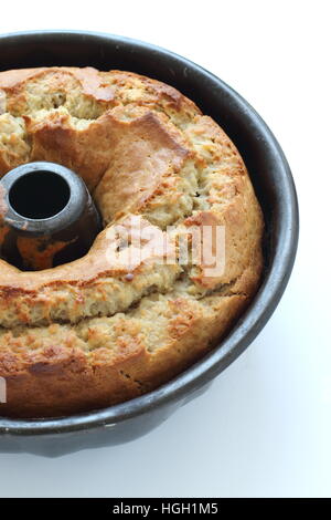 Gâteau banane fraîchement cuit avec une croûte craquelée contre isolé sur fond blanc Banque D'Images