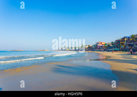 Hôtels au bord de l'eau ligne au-dessus de la plage de sable fin et des vagues de l'océan à une ville touristique au Kerala, en Inde. L'horizontale Banque D'Images