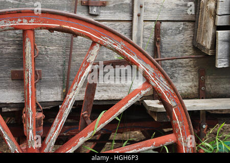 Roue de chariot en bois rouge sur un chariot maison Banque D'Images