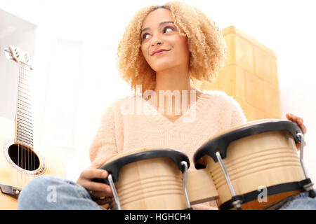 La musique. Créer votre propre musique. Touchant le rythme sur la batterie. Bongos, percussions. Girl playing bongo drums, petits tambours. Banque D'Images