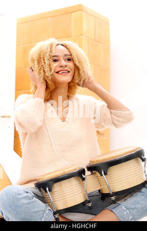 Créer votre propre musique. Touchant le rythme sur la batterie. Bongos, percussions. Girl playing bongo drums, petits tambours. Banque D'Images