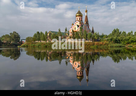 Eglise orthodoxe russe à Almaty, Kazakhstan connu aussi comme église de l'Exaltation de la Sainte Croix, et son reflet dans l'eau. Banque D'Images