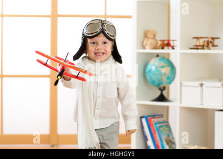 Heureux l'enfant garçon joue avec toy airplane et rêve de devenir pilot Banque D'Images