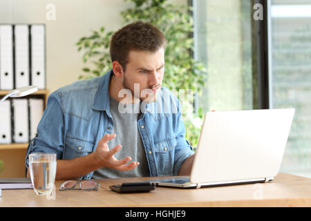 Professionnel Indépendant en colère des problèmes en ligne avec un ordinateur portable dans un bureau à côté d'une fenêtre à l'office de tourisme Banque D'Images