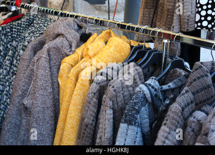 De nombreux vêtements usagés et des vêtements d'hiver accrochés sur des cintres pour vendre au marché aux puces Banque D'Images