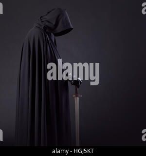 Portrait d'un courageux guerrier errant dans un manteau noir et l'épée à la main. Banque D'Images