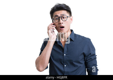 Choqué young man talking on cell phone Banque D'Images