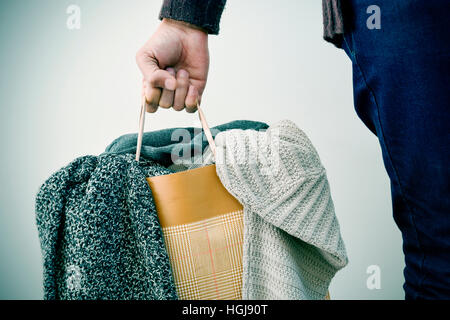 Libre d'un jeune homme de race blanche papier portant un panier rempli de vêtements Banque D'Images