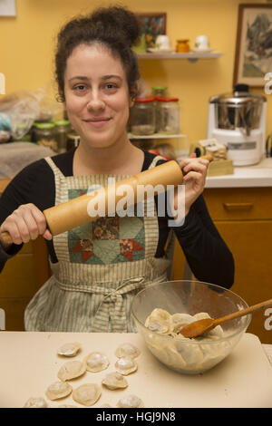 Jeune femme pose avec son rouleau à pâtisserie faire pierogi (raviolis polonais) pour un réveillon de Noël traditionnel à Brooklyn, New York. Banque D'Images