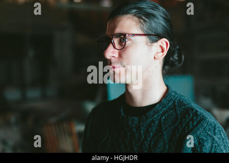 Jeune beau mec avec des lunettes sur fond sombre Banque D'Images