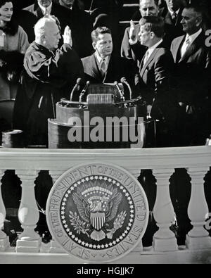 Le président des États-Unis John F. Kennedy est assermenté comme 35e président des États-Unis par le juge en chef de l'United States Earl Warren, à gauche, sur le front de l'Est du Capitole à Washington, DC le vendredi 20 janvier 1961.Crédit : Arnie Sachs/CNP - AUCUN FIL SERVICE - Photo : Arnie Sachs/consolidé Nouvelles Photos/Arnie Sachs - CNP Banque D'Images