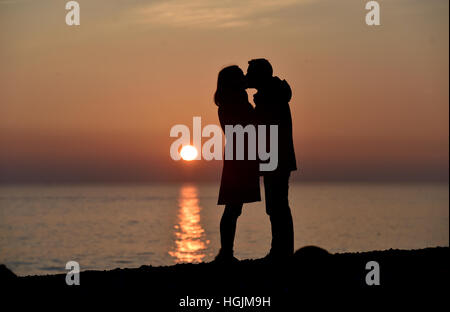 Brighton, Sussex, UK. 22 janvier, 2017. Un couple profitez d'un moment romantique sur la plage de Brighton à mesure que le soleil se couche derrière eux au crépuscule, après une froide mais belle journée sur la côte sud Crédit : Simon Dack/Alamy Live News Banque D'Images