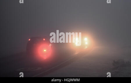 Godshill, New Forest, Hampshire, Royaume-Uni. 23rd janvier 2017. Météo. Conduite dans le brouillard. Les phares antibrouillards et les phares des voitures qui brillent par un épais brouillard givrant rendent les conditions de conduite dangereuses pour les conducteurs un matin d'hiver. Banque D'Images