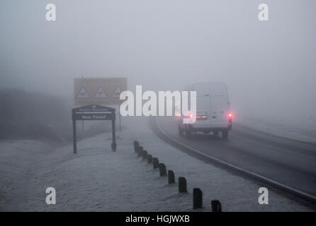 Fourgonnette blanche, conduite sur route de campagne dans un brouillard givrant avec feux de brouillard, janvier, New Forest, Royaume-Uni Banque D'Images