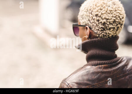 Femme noire avec de courts cheveux blonds portant des lunettes Banque D'Images