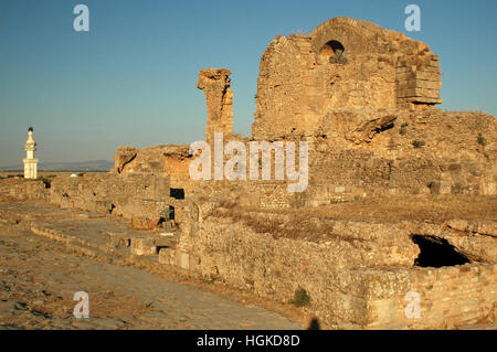 De l'ère romaine ruines semi-souterraine au site archéologique de Bulla Regia, Jendouba, la Tunisie avec la mosquée moderne en arrière-plan Banque D'Images