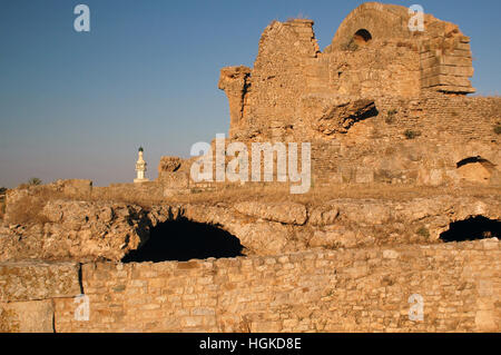 De l'ère romaine ruines semi-souterraine au site archéologique de Bulla Regia, Jendouba, la Tunisie avec la mosquée moderne en arrière-plan Banque D'Images