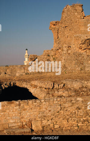 De l'ère romaine ruines semi-souterraine au site archéologique de Bulla Regia, Jendouba, la Tunisie avec la mosquée moderne en arrière-plan Banque D'Images