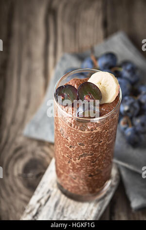 Chia chocolat au lait avec des fruits dans le verre sur la table en bois Banque D'Images