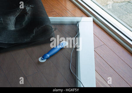 Porte patio vieux déchirés écran remplacés par de nouveaux écran noir Banque D'Images