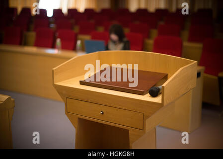Tribune avec un microphone dans une chambre de référence avec une personne à l'arrière-plan Banque D'Images
