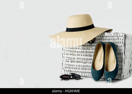 Valise en osier blanc, femmes en chapeau, lunettes et chaussures bleu. Banque D'Images