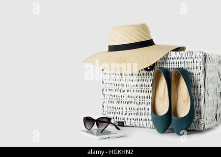 Valise en osier blanc, womens chapeau, lunettes, chaussures bleu et e-book. Banque D'Images