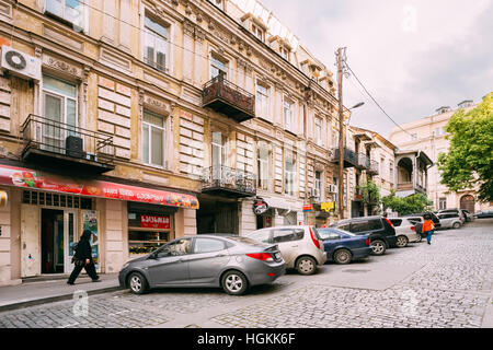 Tbilissi, Géorgie - 20 mai 2016 : Le point de vue de la rue étroite pavée en montée avec une architecture ancienne et d'une rangée de voitures stationnées le long du trottoir en été Da Banque D'Images