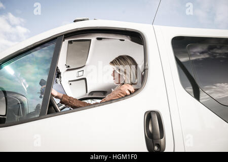 Portrait d'une femme dans sa voiture Banque D'Images