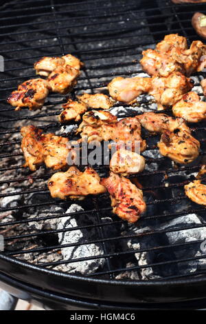 Morceaux de poulet mariné cuisson sur un barbecue Banque D'Images