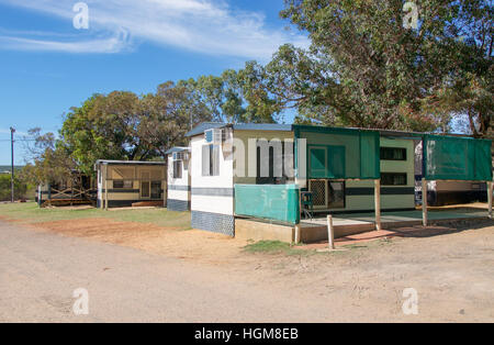 Remorque de camping hébergement en chalet avec des arbres sous un ciel bleu avec des nuages à Kalbarri, ouest de l'Australie. Banque D'Images