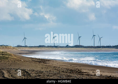 Les éoliennes d'un parc éolien se tenir le long d'une côte sablonneuse de Wexford en Irlande Banque D'Images