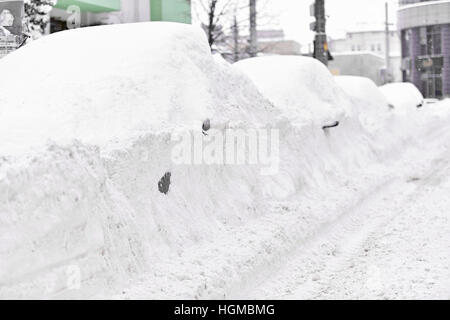 Les voitures sont couvertes de neige plein vu lors d'une forte chute de neige dans la ville Banque D'Images