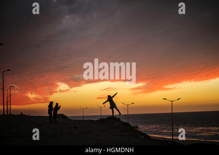 (170110) -- Gaza, 10 janvier 2017 (Xinhua) -- Les Palestiniens sont silhouette sur le coucher du soleil sur la plage dans la ville de Gaza, le 10 janvier, 2017. (Xinhua/Wissam Nassar) Banque D'Images