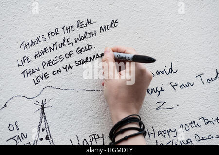 Londres, Royaume-Uni. 10 janvier 2017. Fans de recueillir par l'œuvre de David Bowie dans la maison natale de l'artiste de Brixton pour commémorer le premier anniversaire de la mort du musicien. La murale Brixton qui dépeint le visage de Bowie d'Aladdin Sane couverture de l'album devient le principal lieu de mémoire après la mort de l'étoile le 10 janvier 2016. Wiktor Szymanowicz/Alamy Live News Banque D'Images