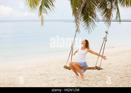 Belle femme Swinging on Beach Banque D'Images