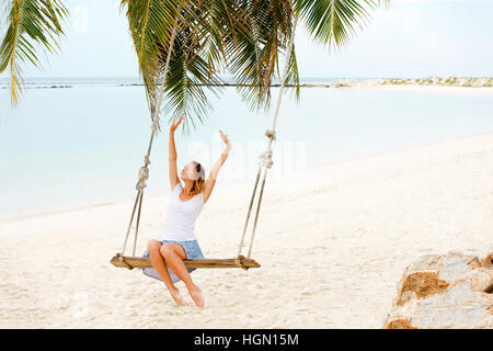 Belle femme Swinging on Beach Banque D'Images