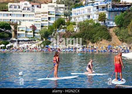 Les vacanciers sur paddle boards avec les touristes de détente sur la plage à l'arrière, Bali, Crète, Grèce, Europe. Banque D'Images